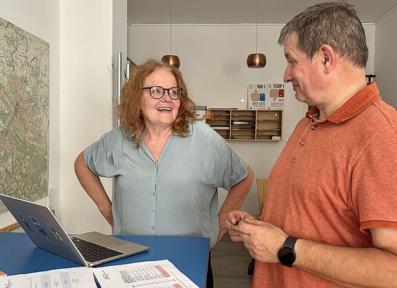Ruth Hachmann und Bernd Diekmann stehen vor einem Stadtplan von Bielefeld 