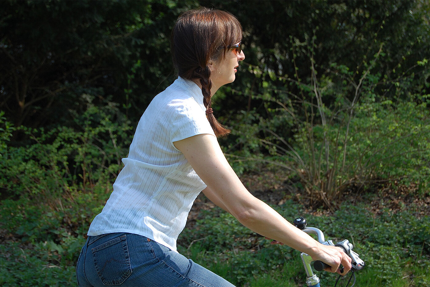 Frau sitzt mit geradem Rücken auf Fahrrad
