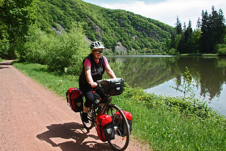 Eifel-5-15_1212_HG_Dingerdissen_1518x1138_b.jpg Frau fährt Rad am Fluss