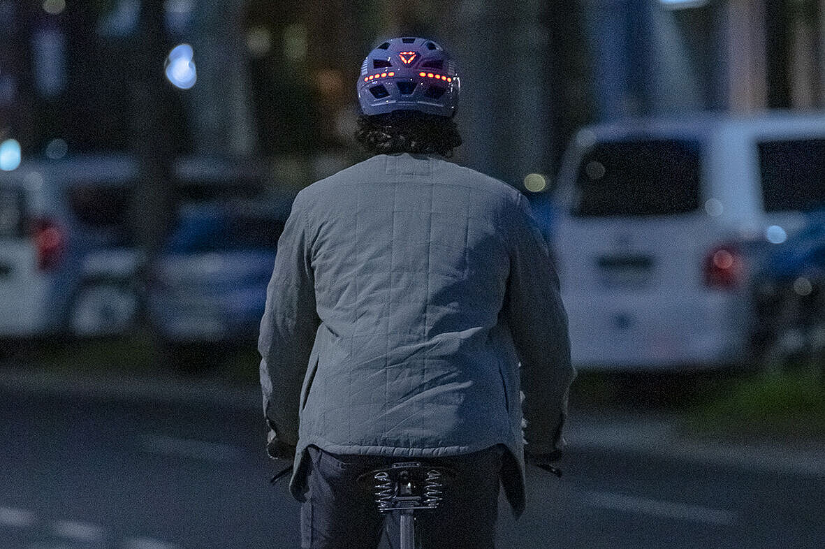 Helm mit Licht vorne Mann auf Fahrrad mit Helm, der hinten rot leuchtet